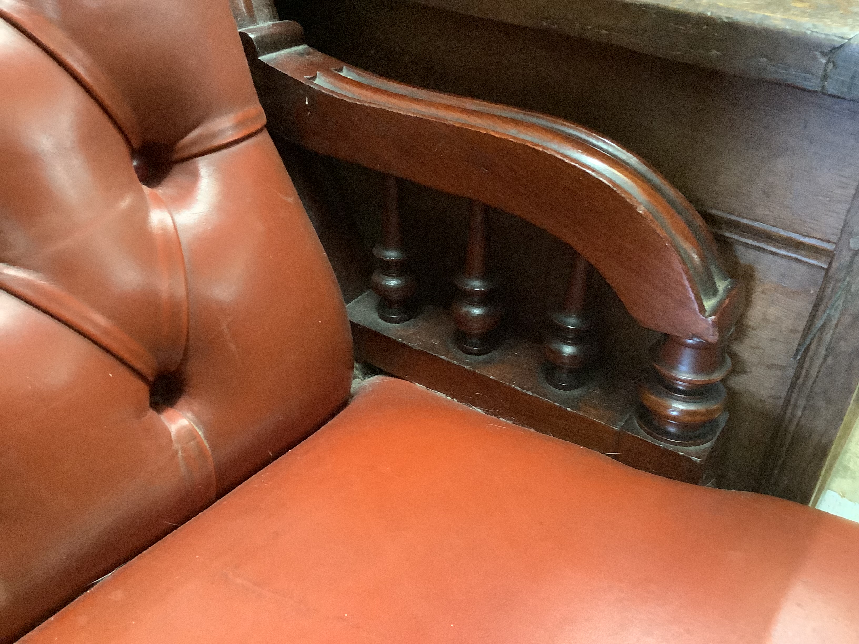 A Victorian mahogany easy chair, upholstered in buttoned red hide